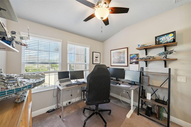 carpeted home office featuring baseboards, ceiling fan, and lofted ceiling