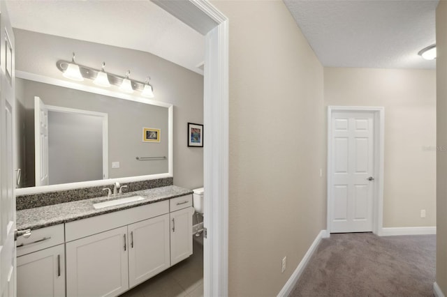 bathroom with vanity, baseboards, and toilet