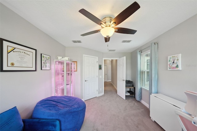 living area featuring baseboards, ceiling fan, carpet flooring, and visible vents