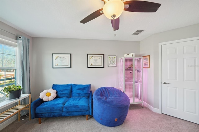 living area with carpet floors, ceiling fan, and visible vents
