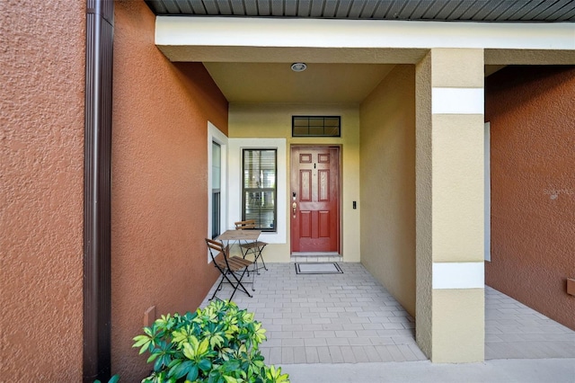 doorway to property featuring stucco siding