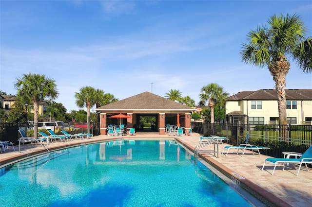 pool featuring fence and a patio area