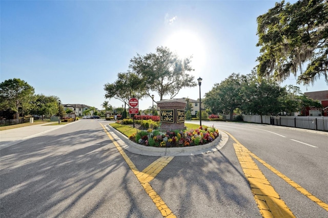 view of street featuring street lighting, traffic signs, sidewalks, and curbs
