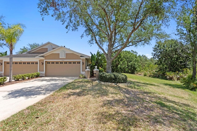 view of front of home with a garage, a front lawn, stucco siding, and concrete driveway