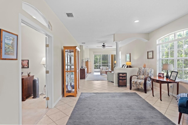 interior space with baseboards, visible vents, light tile patterned floors, and decorative columns