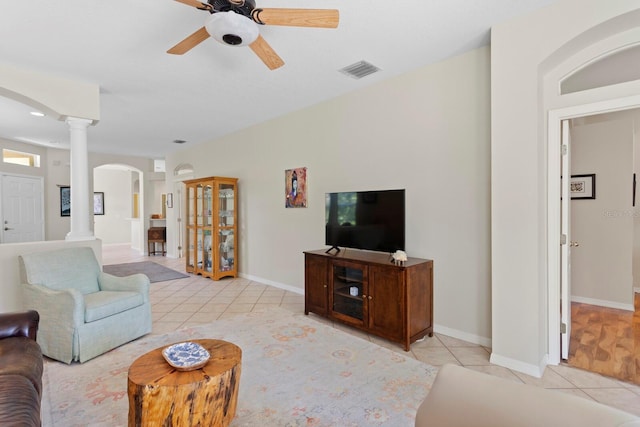 living area with light tile patterned flooring, visible vents, arched walkways, and decorative columns
