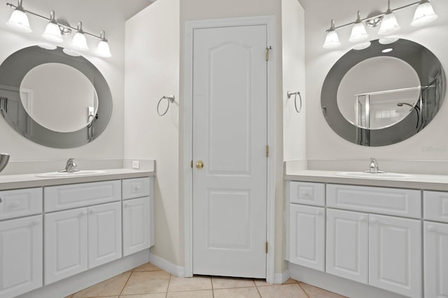 bathroom with tile patterned flooring, two vanities, and a sink