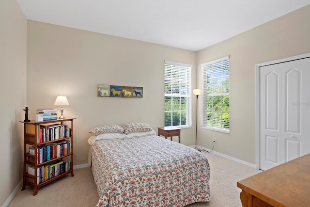 bedroom featuring baseboards and light carpet