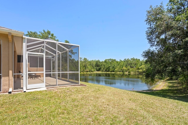 view of yard with a water view, a patio, and glass enclosure