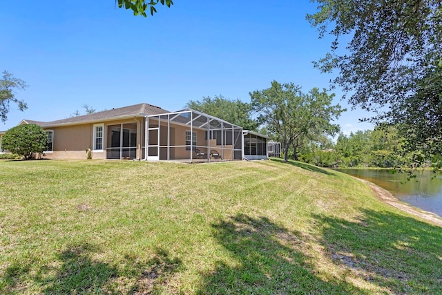 rear view of property featuring a yard, a water view, and a lanai