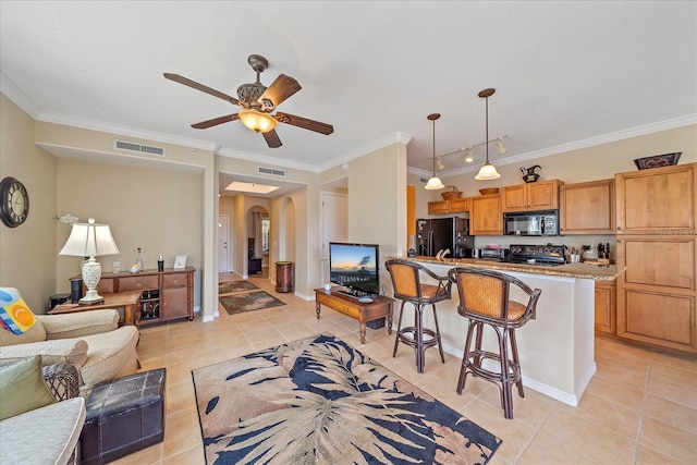 600 Gardens Edge Dr Unit 614, Venice, FL 34285 - living room with light tile patterned floors, crown molding, arched walkways, ceiling fan, and baseboards
