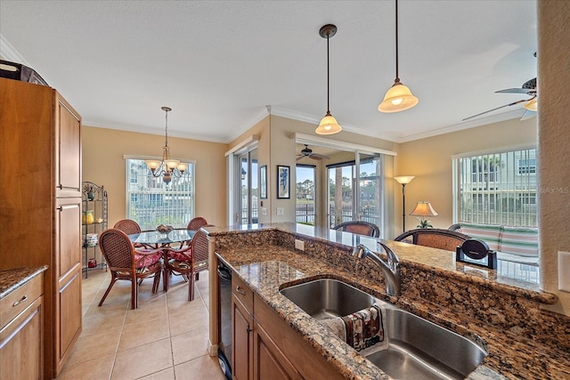 600 Gardens Edge Dr Unit 614, Venice, FL 34285 - kitchen featuring ceiling fan, a sink, brown cabinetry, hanging light fixtures, and crown molding