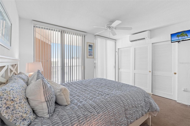 bedroom featuring carpet floors, a textured ceiling, a wall unit AC, and multiple windows