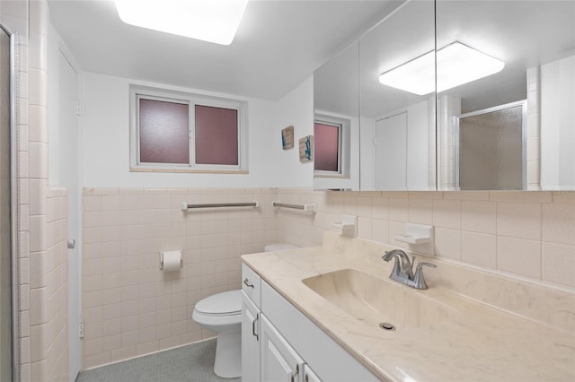 bathroom featuring a stall shower, vanity, tile walls, toilet, and tile patterned flooring