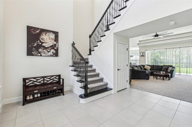 3952 Bonfire Dr, Odessa, FL 33556 - stairway featuring carpet, a ceiling fan, baseboards, a towering ceiling, and tile patterned flooring