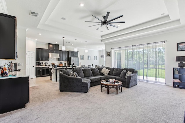 3952 Bonfire Dr, Odessa, FL 33556 - living room featuring a tray ceiling, light carpet, visible vents, and ceiling fan