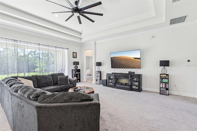 3952 Bonfire Dr, Odessa, FL 33556 - carpeted living room with a tray ceiling, a fireplace, visible vents, baseboards, and ceiling fan
