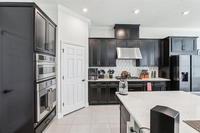 3952 Bonfire Dr, Odessa, FL 33556 - kitchen with under cabinet range hood, light tile patterned floors, ornamental molding, backsplash, and stainless steel appliances