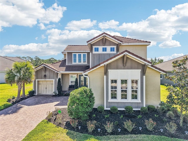 3952 Bonfire Dr, Odessa, FL 33556 - view of front of property featuring board and batten siding, decorative driveway, a garage, stucco siding, and a front yard