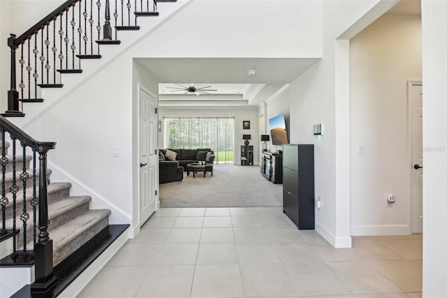 3952 Bonfire Dr, Odessa, FL 33556 - entryway with stairs, light carpet, a ceiling fan, light tile patterned floors, and baseboards