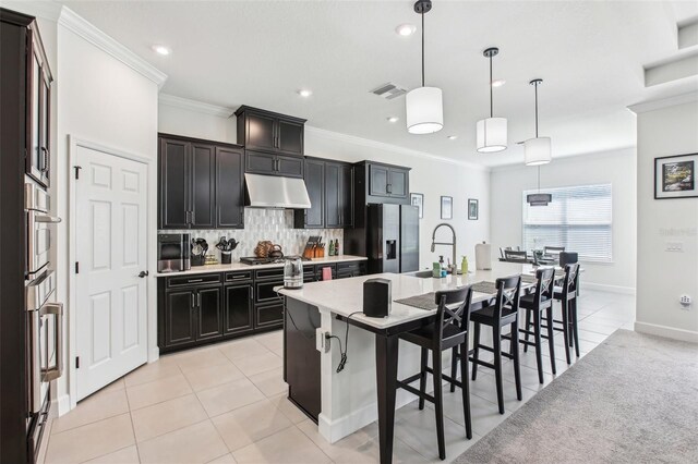 3952 Bonfire Dr, Odessa, FL 33556 - kitchen with under cabinet range hood, visible vents, a sink, stainless steel fridge with ice dispenser, and a kitchen breakfast bar