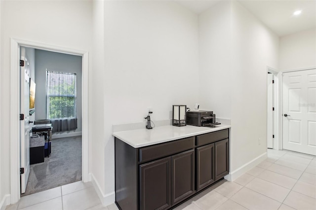 3952 Bonfire Dr, Odessa, FL 33556 - bar featuring a towering ceiling, baseboards, light tile patterned flooring, and light colored carpet