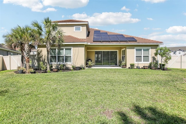3952 Bonfire Dr, Odessa, FL 33556 - back of property with a lawn, stucco siding, solar panels, and a fenced backyard