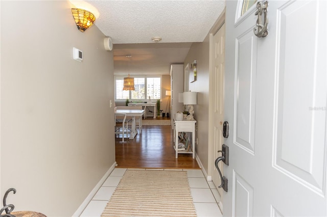 1581 Gulf Blvd Unit 301N, Clearwater Beach, FL 33767 - corridor with baseboards, a textured ceiling, and light tile patterned flooring