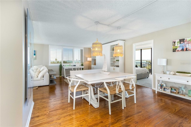 1581 Gulf Blvd Unit 301N, Clearwater Beach, FL 33767 - dining room featuring wood finished floors, a textured ceiling, and baseboards