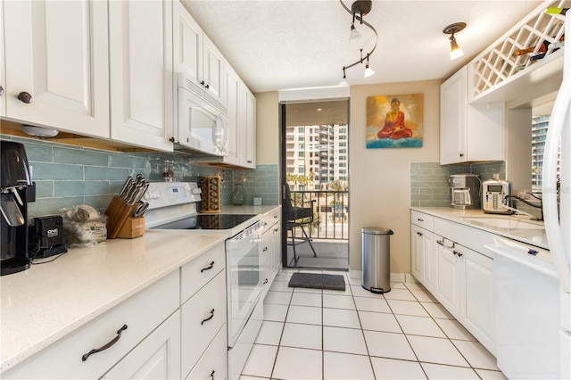 1581 Gulf Blvd Unit 301N, Clearwater Beach, FL 33767 - kitchen with a healthy amount of sunlight, white cabinetry, a sink, and white appliances