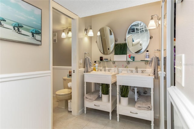 1581 Gulf Blvd Unit 301N, Clearwater Beach, FL 33767 - full bath with a sink, double vanity, toilet, wainscoting, and tile patterned flooring
