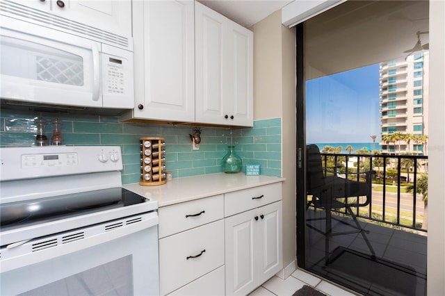1581 Gulf Blvd Unit 301N, Clearwater Beach, FL 33767 - kitchen with white appliances, white cabinetry, light countertops, backsplash, and light tile patterned flooring