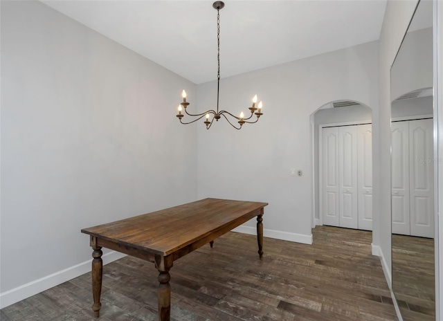 dining area with baseboards, arched walkways, wood finished floors, and a chandelier