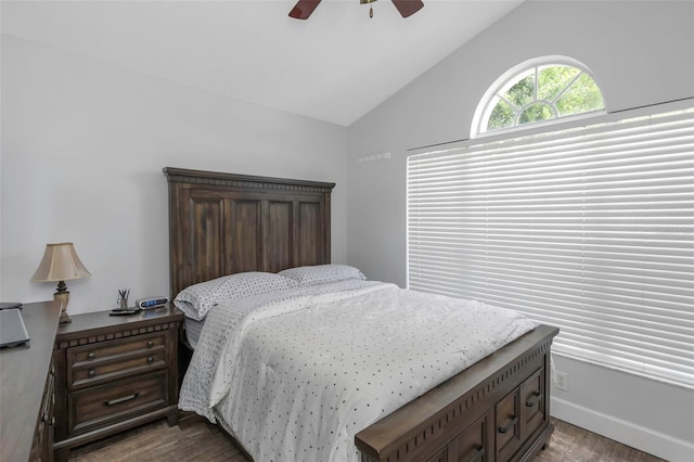 bedroom with ceiling fan, dark wood-type flooring, and lofted ceiling