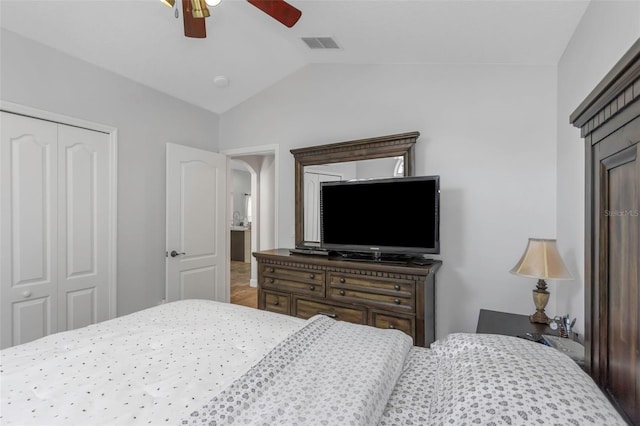 bedroom featuring a ceiling fan, vaulted ceiling, visible vents, and a closet