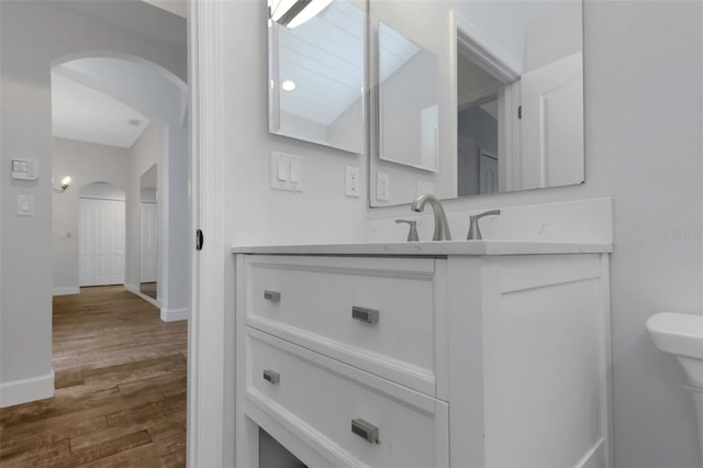 bathroom with vanity, baseboards, and wood finished floors
