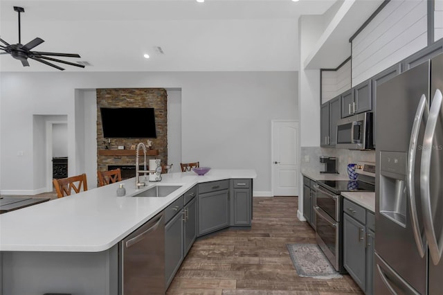 kitchen with ceiling fan, light countertops, a sink, appliances with stainless steel finishes, and gray cabinetry