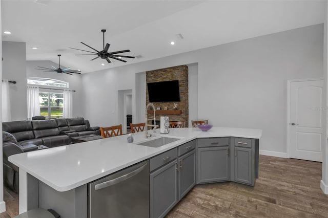 kitchen featuring open floor plan, a sink, gray cabinets, and dishwasher