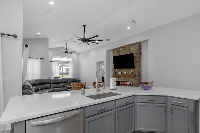 kitchen featuring a sink, light countertops, gray cabinets, open floor plan, and stainless steel dishwasher