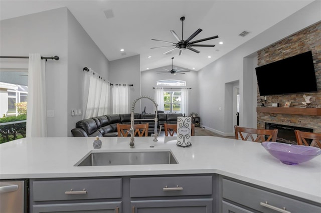 kitchen featuring open floor plan, a sink, gray cabinetry, and light countertops