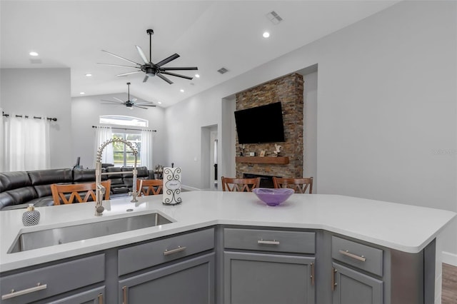 kitchen featuring light countertops, open floor plan, gray cabinetry, and a sink