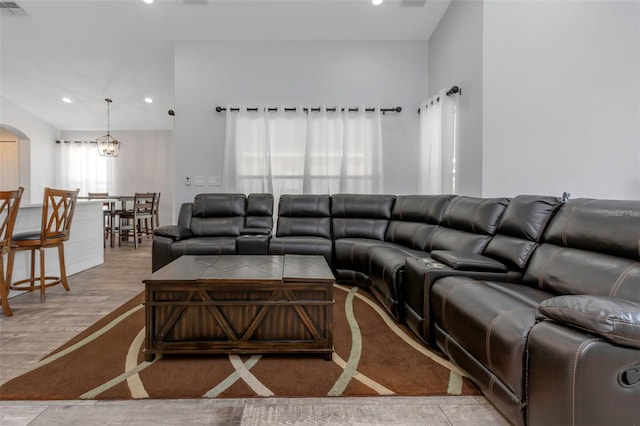 living area featuring arched walkways, recessed lighting, and wood finished floors