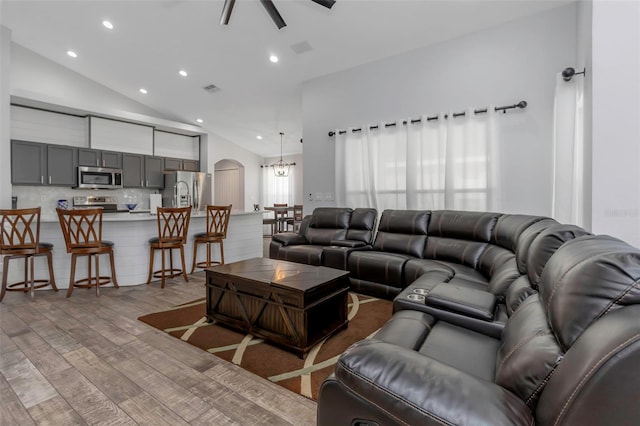living area featuring visible vents, ceiling fan, light wood-type flooring, recessed lighting, and arched walkways