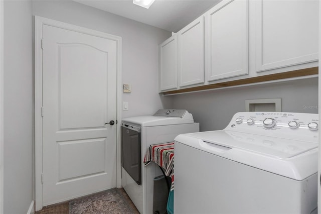 laundry area with separate washer and dryer and cabinet space