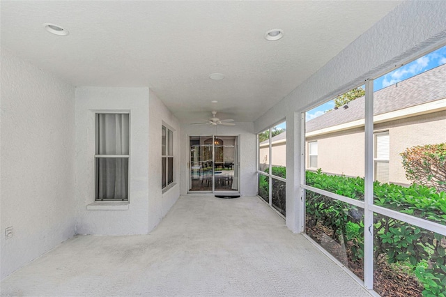 unfurnished sunroom featuring a ceiling fan