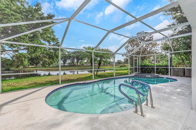 view of swimming pool with a yard, a water view, a pool with connected hot tub, and a patio area