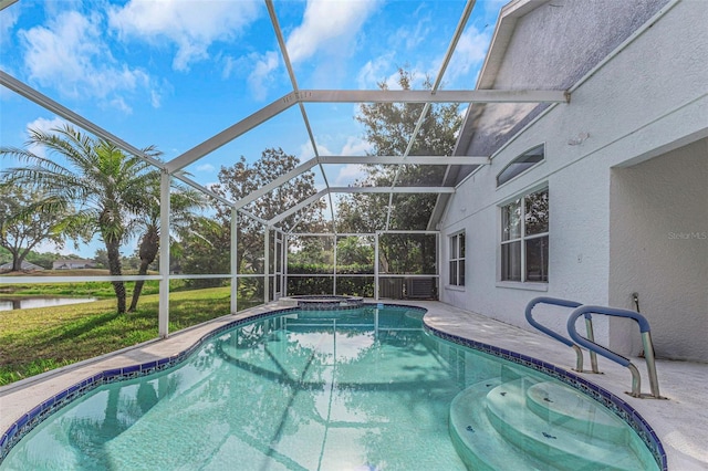 view of swimming pool featuring a patio, a pool with connected hot tub, and glass enclosure