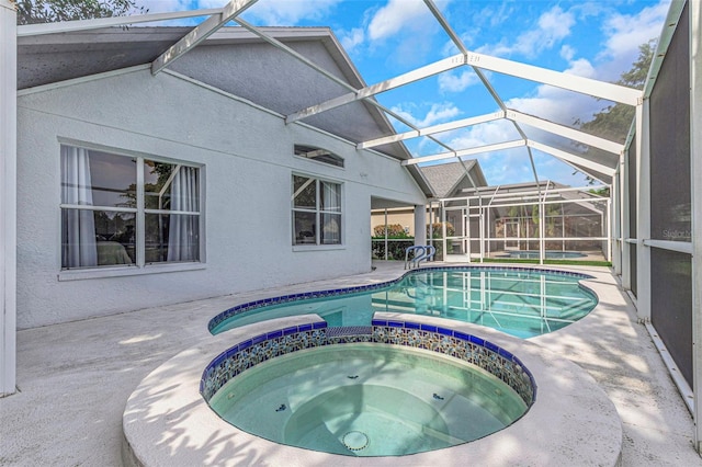 view of pool featuring a patio, glass enclosure, and a pool with connected hot tub
