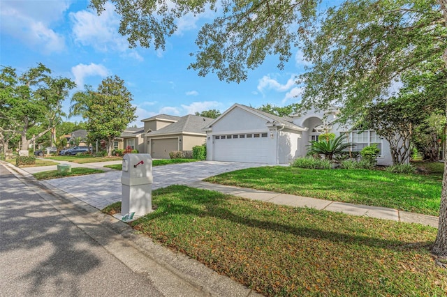 view of front of home with a garage, a front yard, stucco siding, driveway, and a residential view