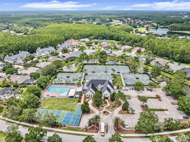 drone / aerial view featuring a residential view, a water view, and a forest view